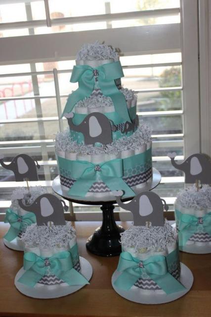 bolo fake masculino com laços da cor azul clara e desenhos de elefante cinza