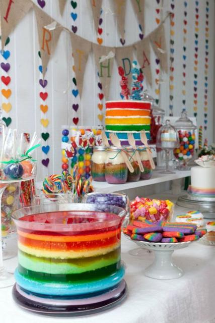 cortina de corações colorida e mesa de doces com bolo das mesmas cores