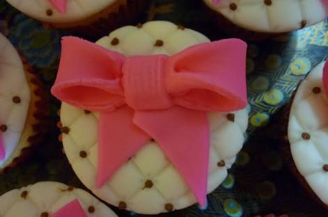 cupcake branco com lacinho rosa e bolinhas para confeitas