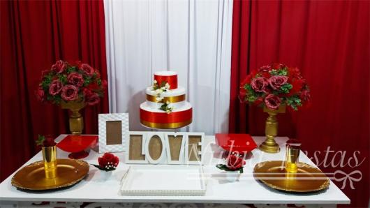 mesa de bolo com fitas vermelhas e douradas