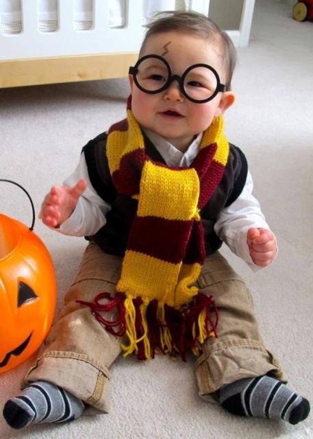Menino vestido de Harry Potter, com cachecol amarelo e bordo, óculos e com maquiagem imitando a cicatriz do personagem.