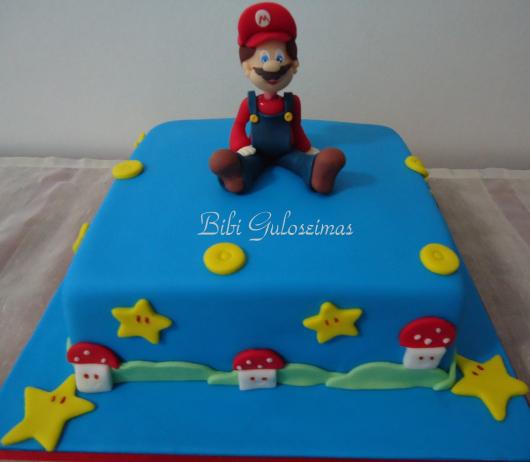 Bolo azul em pasta americana com boneco do Mario.