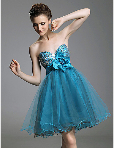 Modelo usa vestido azul curto com detalhe de laço, modelo tomara que caia.