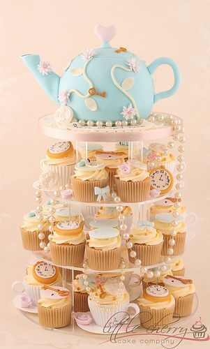 Porta cupcake rosa com chaleira azul em cima.