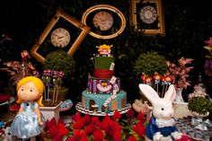 Mesa do bolo, com bonecos de personagens e flores.