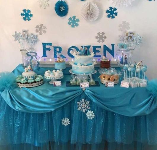 Decoração de Festa Simples Frozen com enfeites de papel e mesa decorada com cetim