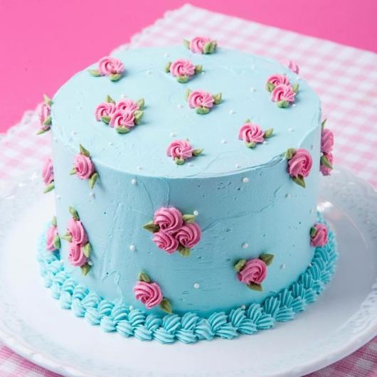 Decoração simples de aniversário com bolo azul e detalhes em rosa