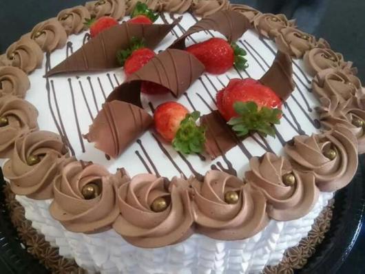 Decoração simples de aniversário com bolo de chocolate com morangos