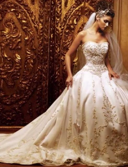 Modelo usa vestido de noiva branco tomara que caia com brilhos, véu longo de tule.