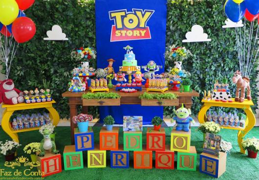 Festa Toy Story decorada com blocos de MDF com o nome do aniversariante e painél de tecido com aplique de papel