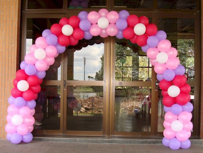 Arco de balões com flores lilás e vermelhas