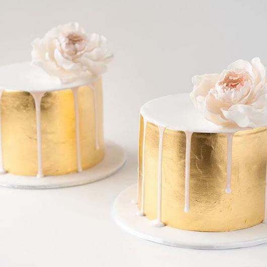 Ideia bem refinada de bolo simples dourado com flor natural