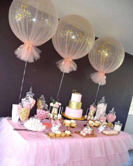 Ideia para você decorar a mesa da festa com balão transparente com glitter e tule