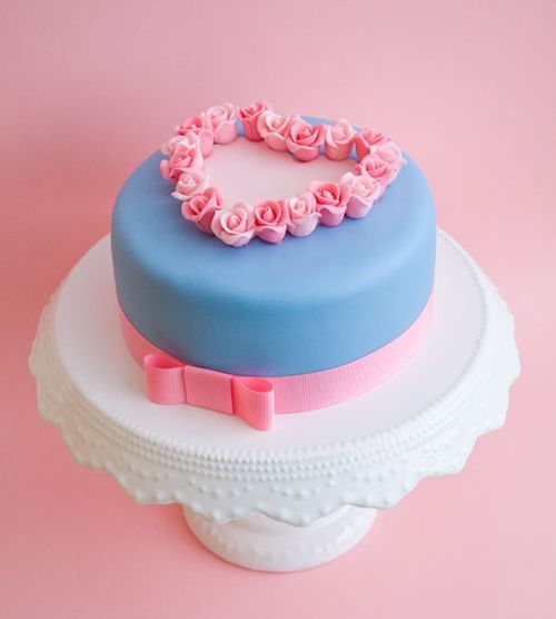 Bolo pequeno azul e rosa com decoração de coração