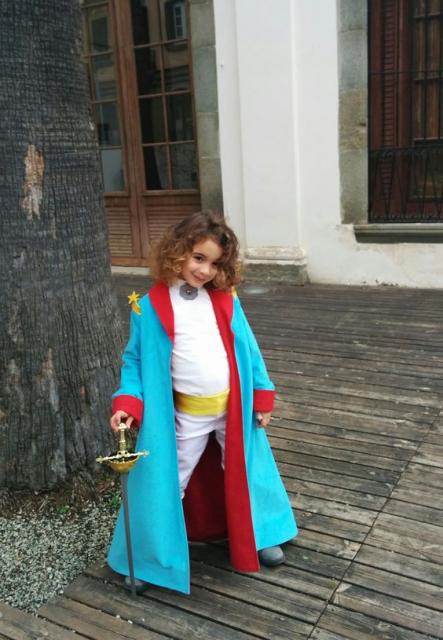 Menina com fantasia Pequeno Príncipe, com capa azul clara.