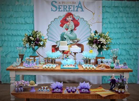 Mesa de Festa Infantil com Tema Pequena Sereia decorada com doces personalizados