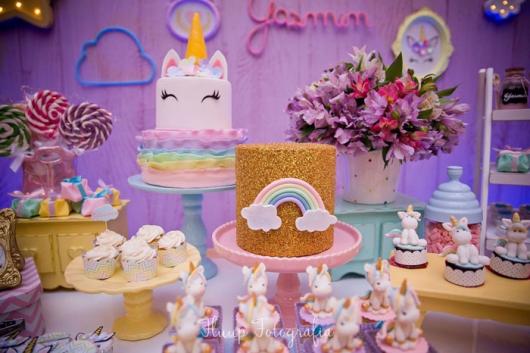 Mesa de Festa Infantil com Tema Unicórnio decorada com bolo fake dourado