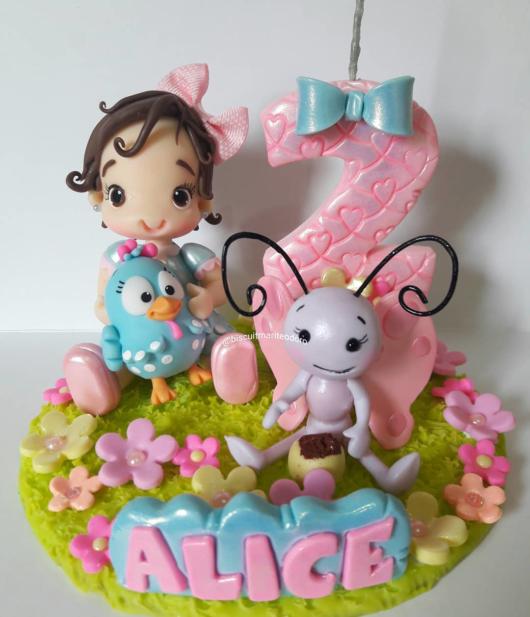 topo de bolo galinha pintadinha com uma menininha de boneca.