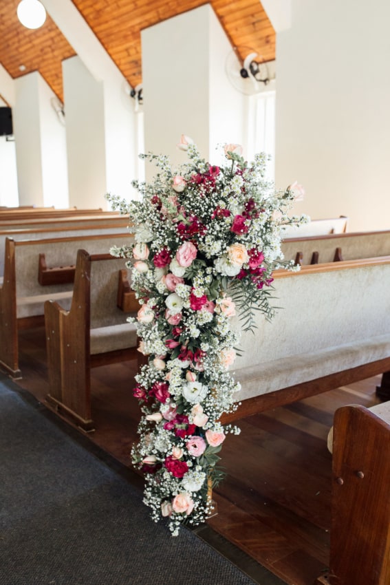 Bancos de igreja com arranjos de flores