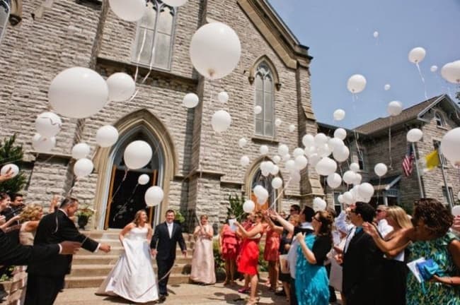 Saída dos noivos com balões brancos