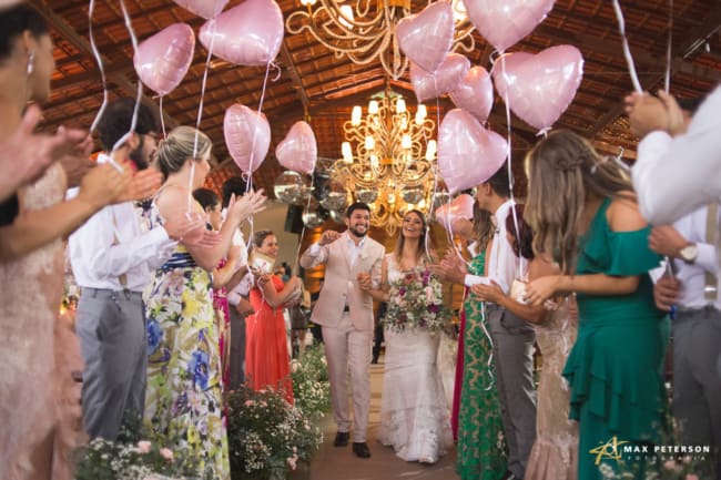 Saída dos noivos com balões rosa