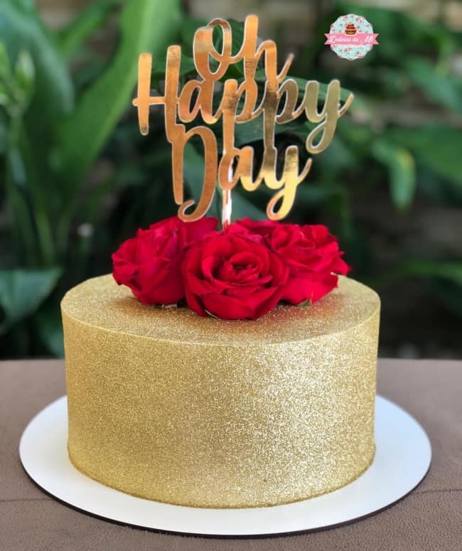 glow cake dourado com rosas vermelhas no topo